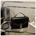 Elegante bolso de mano en cuero negro con cierre giratorio dorado y correa ajustable - Negro
