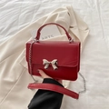 Borsa quadrata in pelle PU rossa con fiocco in metallo argento e catena in mano - Borgogna