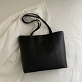 Matte black leather tote bag with long straps displayed on a white textured background - Black