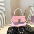 Elegant pink handbag with textured flap and gold buckle in a minimalist studio setting - Pink