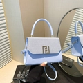Minimalist light blue handbag with woven flap and geometric gold hardware in modern setting - Blue