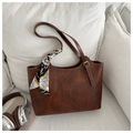 Detail of vintage brown leather tote bag with decorative silk scarf and metal buckle - Tan