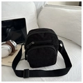 Bolso bandolera de pana negra con múltiples bolsillos con cremallera en un sofá - Negro