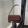 Chique donkerbruine suède schoudertas met gebogen klep en een minimalistisch design - Bruin