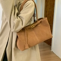 Detalle del bolso tote de ante camello con correas decorativas y hebillas doradas - Marrón