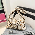 Chic leopard print faux fur shoulder bag for winter displayed on denim fabric - White