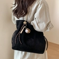 Black suede bucket bag with gold chain strap and baseball charms on female model - Black With Braided Rope Baseball Charm