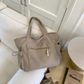 Sac cabas en velours côtelé marron clair avec poche zippée et cordon sur canapé - Kaki