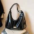Glossy black hobo shoulder bag with a metallic plaque on a chic suitcase background - Black without Pendant