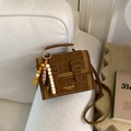 Brown suede crossbody bag with leopard texture and gold stud details on white sofa - Brown With Beaded Charm