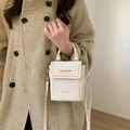Sac bandoulière blanc cassé élégant avec clous dorés porté par un mannequin en manteau - Sans Pendentif / Blanc