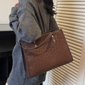 Large leopard print tote bag in dark brown with leather handles worn by a model - Coffee - No Pendant