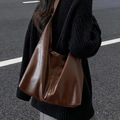 Large brown vintage PU leather tote bag shown in a stylish street style casual setting - Coffee