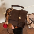 Bolso bandolera retro marrón oscuro con asa de metal circular y borla decorativa - Café Con Colgante de Bola de Peluche