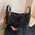Chic black leopard print crescent shoulder bag with dark texture and plush tassel charm - Black Leopard Print (With Charm) / Black