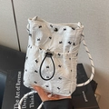 Ruched white phone bag with black bow patterns and a woven shoulder strap design - White
