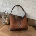 Donkerbruine hobo schoudertas van suède en leer met contraststiksels en metalen ring - Bruin