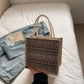 Ethnic pattern tote bag in purple and brown hues with thick rope handles on white bedding - Khaki Zipper Style