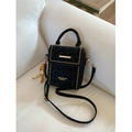 Chic black leopard print crossbody bag with gold studs and beaded charm on white sofa - Black With Bead Charm