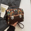 Sac à main rétro en cuir marron avec motif matelassé orange et vert tenu à la main - Vert