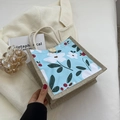 Light blue floral lunch tote bag with jute handles and a wooden button closure - Blue