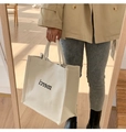 Minimalistische cremeweiße Canvas-Tragetasche mit merci-Aufdruck und robusten Griffen - Weiß