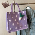 Lila Canvas-Tragetasche mit weißen Nummernprints und einem grünen Anhänger - Mit Ornament / Lila