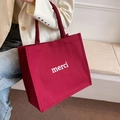 Burgundy canvas tote bag with white merci print and wide handles for casual wear - Red