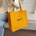 Yellow canvas tote bag with black merci print, minimalist French style for daily use - Yellow