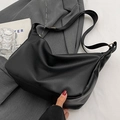 Elegante borsa a tracolla nera in pelle martellata con ampia cinghia su abito grigio - Nero senza Ciondolo