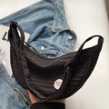 Minimalistische schwarze Halbmond-Segeltuchtasche mit Good Luck-Patch auf weichem Stoff - Schwarz (Inklusive Acryl-Abzeichen)