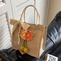 Borsa tote beige intrecciata con fiocco in pizzo e fiori in maglia su divano nero - Rosa Con Sciarpa In Pizzo