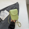 Schicke hellgrüne Handytasche mit Litschitextur und goldener Kette auf einem Blazer - Grün