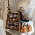 Bruine geruite crossbody tas met kersen hanger gedragen door een model - Bruin Met Kaki Kersenhanger