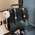 Vintage black faux leather backpack with suede panels and a cute plush monster charm - Black + White Elf Charm