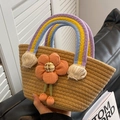 Handgewebte Strohtasche mit Regenbogen-Griffen und orangefarbener Blume - Dunkelbeige