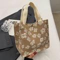 Khaki canvas tote bag with floral embroidery and gold buckle shown held in hand - Small Khaki