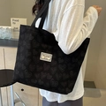 Bolso tote negro grande con diseño de corazones texturizado y etiqueta blanca - Grande / Negro