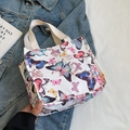 Witte canvas draagtas met kleurrijke vlinderprint en beige geweven handgrepen - Klein Roze