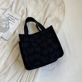 Chic black canvas tote bag with subtle heart pattern and sturdy handles on a white fabric - Small Black
