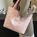 Pink tote bag with 3D rose jacquard pattern and woven handles shown on a model shoulder - Large Pink (Lined/Zipper/No Inner Pocket)
