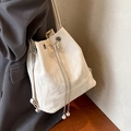 Bolso saco beige con cordón, adornos de mariposa y perlas sobre tejido texturizado - Blanco