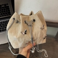 Elegant beige bucket bag with marble texture and silver butterfly pendant detail - Khaki