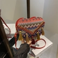 Ethnic heart-shaped woven crossbody bag featuring colorful geometric patterns and tassels - Red