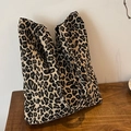 Large leopard print tote bag in woven canvas placed on a dark wood table for daily commute - Yellow Leopard Print