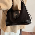 Elegante zwarte tote bag van gemengd materiaal met gouden gesp gedragen door een model - Zwart