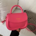 Vibrant magenta saddle bag with golden text and elegant curved handle for women - Pink