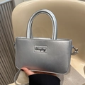 Metallic silver crossbody handbag with rounded handle and vintage script logo plaque - Silver