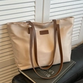 Große beige Shopper-Tasche mit braunen Ledergriffen und modischem Logo-Aufnäher - Gebrochenes Weiß