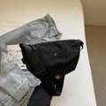 Borsa a tracolla minimalista in nylon nero con logo in metallo su giacca di jeans blu - Nero